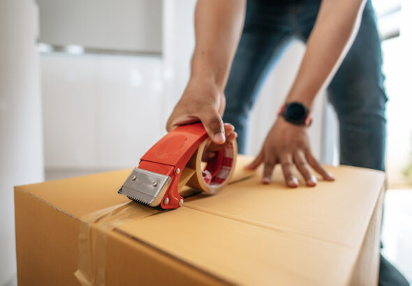 Man som tejpar igen flyttkartong